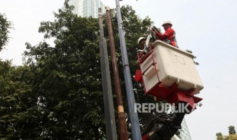 Pekerja membongkar tiang penerangan jalan umum (PJU) (ilustrasi). Pemkot Depok menerjunkan belasan personel untuk memantau kondisi PJU.