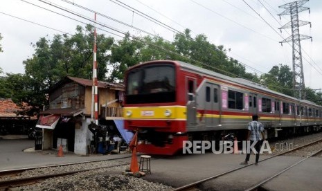 Kereta commuter line melintas di dekat perlintasan pintu kereta api yang tidak berfungsi menutup di Jalan Administrasi Negara, Bendungan Hilir, Tanah Abang, Jakarta Pusat, Senin (26/2).