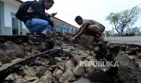 Warga melihat kondisi area parkir ruang tunggu yang retak akibat gempa di Pelabuhan Kayangan, Lombok Timur, NTB, Selasa (21/8).