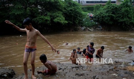 Anak-anak bermain air di aliran Sungai Ciliwung di kawasan Manggarai, Jakarta, Selasa (9/4).