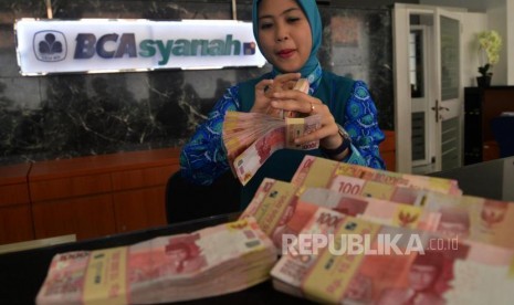 Karyawan melayani transaksi setoran nasabah di BCA Syariah. ilustrasi