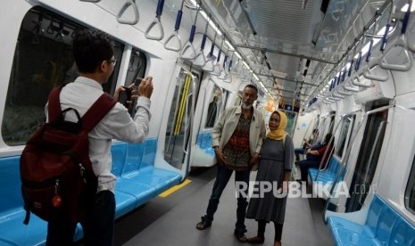 Warga berfoto saat menaiki kereta MRT di Stasiun Bundaran HI, Jakarta, Senin (25/3).