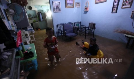 Sejumlah anak beraktivitas dirumahnya saat banjir akibat luapan Kali Ciliwung di Kebon Pala, Kampung Melayu, Jakarta, Senin (5/2).