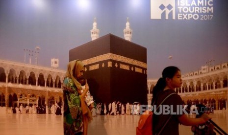 Pengunjung melintas di depan gambar kabah saat Pameran umrah haji dan wisata muslim, Islamic Tourism Expo 2017 di Jakarta, Rabu (11/10).  