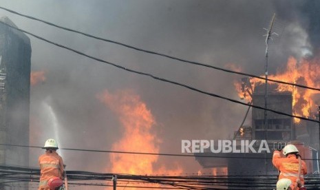 Kebakaran Pemukiman di Manggarai. Petugas pemadam kebakaran berusaha memadamkan api dari kebakaran yang terjadi di pemukiman padat penduduk di Jalan Lebak Swadaya I, Kampung Bali daerah Matraman, Jakarta, Rabu (10/7).