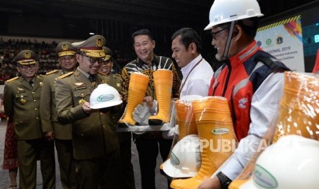 Menteri Ketenagakerjaan M. Hanif Dhakiri (keempat kanan) bersama Direktur Pelayanan BPJS Ketenagakerjaan Krishna Syarif (ketiga kanan) menyerahkan Alat Pelindung Diri (APD) kepada pekerja sektor konstruksi seusai upacara bulan K3 Nasional tahun 2019 di Jakarta, Selasa (15/1).