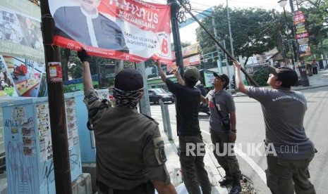 Penertiban Atribut Kampanye. Petugas Satpol PP bersama Badan Pengawas Pemilu (Bawaslu) Jawa Barat menertibkan atribut kampanye, di Jalan LRE Martadinata, Kota Bandung, Jumat (8/3).