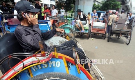 Tukang becak saat menunggu untuk didata oleh petugas di kolong flyover Bandengan Utara, Pekojan, Tambora, Jakarta Barat, Jumat (26/1).