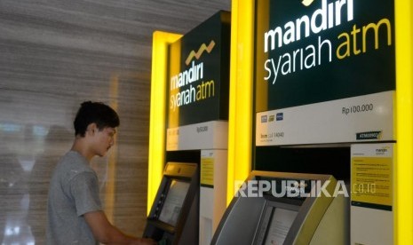 Nasabah melakukan transaks melalui ATM Bank Syariah Mandiri di Jakarta, Ahad (21/10).