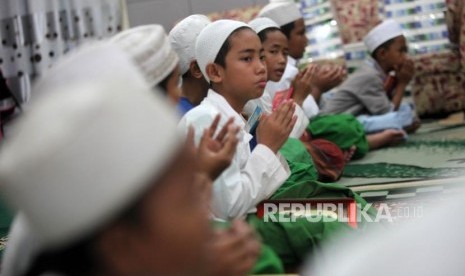 Sejumlah santri berdoa seusai mengaji kitab kuning di Pesantren Ilmu Alquran Al Misbah, Jalan Bahari, Jakarta, Jumat (25/5).