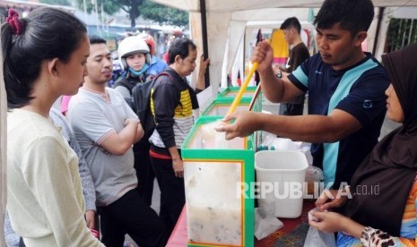 Warga mencari takjil untuk berbuka puasa di stan bazar Ramadhan di Masjid Jami Matraman, Jakarta, Selasa (22/5).