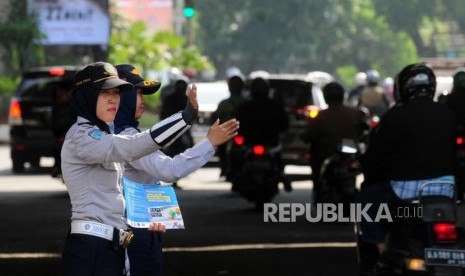 Petugas Dinas Perhubungan mengatur lalu lintas saat uji coba perluasan ganjil genap di kawasan Pancoran, Jakarta Selatan, Senin (2/7).