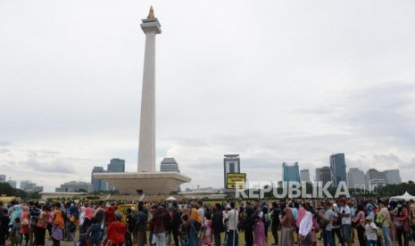 ejumlah warga mengantri untuk masuk ketugu monas, Jakarta, Selasa (1/1).