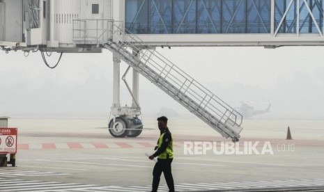 Sejumlah pekerja saat melintas di Bandara Sultan Syarif Kasim (SSK) II, Pekanbaru, Riau, Selasa (17/9).