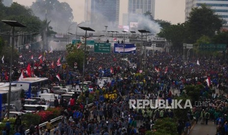 BLOKIR TOL . Asap gas air mata mengepul dari kejauhan saat mahasiswa memblokade jalan tol dalam pada aksis di depan Kompleks Gedung Parlemen RI, Selasa (24/9).