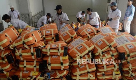 Sejumlah porter merapihkan koper calon jamaah haji di Asrama Haji Pondok Gede, Jakarta, Ahad (14/7).