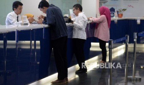 Petugas melayani nasabah ketika melakukan transaksi di Bank Mandiri, Kantor Cabang Plaza Mandiri, Jakarta, Senin (10/6).