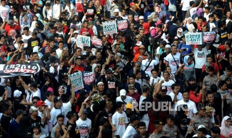 Participants of #2019GantiPresiden movement hold a banner at Hotel Indonesia Roundabout during Car Free Day, Jakarta, Sunday (April 29).