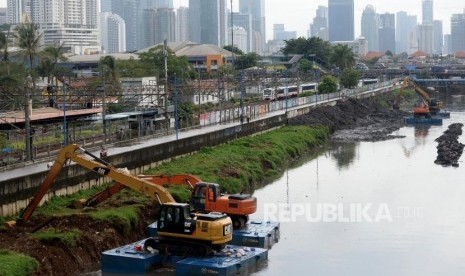 Pekerja dengan menggunakan alat berat mengeruk endapan sampah yang bercampur lumpur di aliran Sungai Ciliwung, Kanal Banjir Barat, Jakarta, Sabtu (20/1).