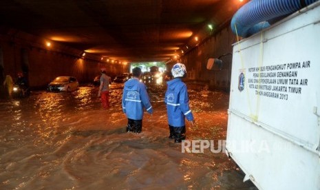 Petugas menyiapkan pompa untuk menyedot genangan air di terowongan Cawang, Jakarta, Selasa (12/12).