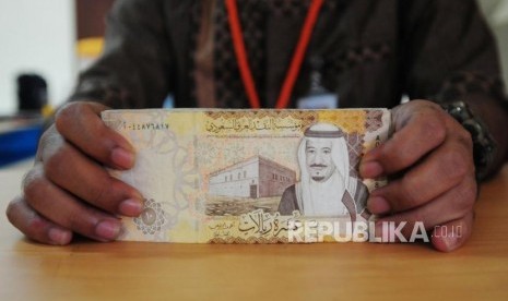 Petugas memperlihatkan mata uang Saudi Riyal di Asrama Haji Pondok Gede, Jakarta, Senin (23/7).