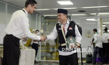 Petugas memberikan bunga kepada calon jamaah haji usai mencoba fasilitas fast track pada acara pelepasan jamaah haji Indonesia asal DKI Jakarta di Bandara Internasional Soekarno Hatta, Tangerang, Ahad (7/7).