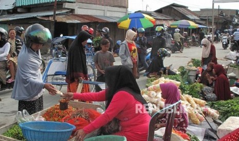 Pembeli melakukan transaksi dengan pedangan di pasar Impres Palu, Sulawesi Tengah, Sabtu (20/10).