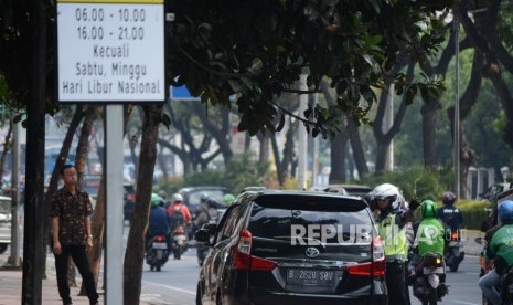 Petugas kepolisian mengamankan kendaraan roda empat di kawasan perluasan ganjil genap Jalan Majapahit, Jakarta, Senin (9/9/2019).