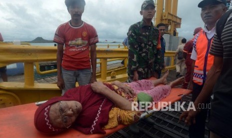 Sejumlah petugas mengevakuasi warga yang sakit di Dermaga 5 Pelabuhan Bakauheni, Lampung Selatan, Rabu (26/12).