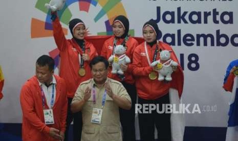 Ketua Umum Pengurus Besar Ikatan Pencak Silat Seluruh Indonesia Prabowo Subianto saat akan memberikan medali kepada Pesilat Indonesia Pramuditya Yuristya, Lutfi Nurhasanah dan Gina Tri Lestari usai pertandingan cabang olahraga silat Asian Games 2018 kategori regu putri di Padepokan Pencak Silat TMII, Jakarta, Rabu (29/8).