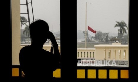 Pengunjung memotret bendera setengah tiang berkibar di Istana Siak Sri Indrapura, Kabupaten Siak, Riau, Selasa (10/9).