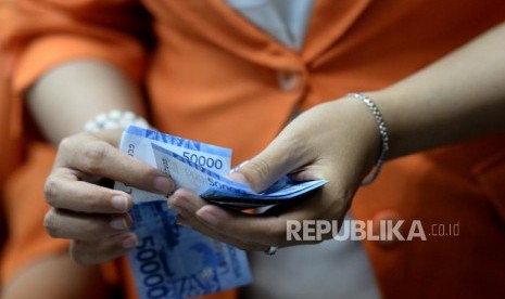 Transaksi Mata Uang Lokal. Petugas menghitung mata uang rupiah di jasa penukaran uang. ilustrasi