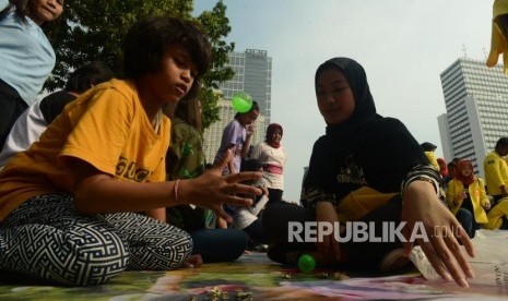 Anak-anak saat bermain permainan tradisional saat Hari Bebas Kendaraan Bermotor (HBKB) di Jalan Jenderal Sudirman, Jakarta, Ahad (18/11).