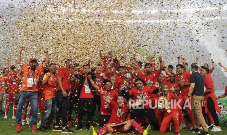 Pemain dan pengurus Persija Jakarta mengangkat piala seusai mengalahkan Mitra Kukar dalam laga Liga 1 2018 di di Stadion Utama Gelora Bung Karno, Jakarta, Ahad (9/12).