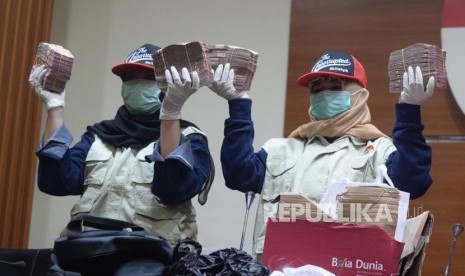 Petugas  KPK  menunjukan barang bukti operasi  tangkap tangan yang  dilakukan Komisi Pemberantasan Korupsi terhadap di Jakarta, Rabu (12/12).