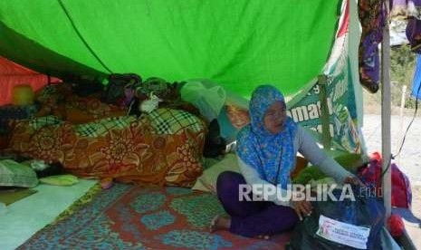 Seorang warga pengungsi menyusun paket sembako dari ACT ke dalam tenda pengunsiannya di Duyu, Palu Barat, Kecamatan Tatanga, Selasa (9/10).