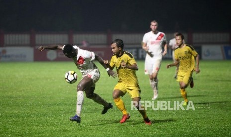 Penyerang PSM Makassar Nke Ondoua Guy (kiri) duel bola dengan Bek Bhayangkara FC Muhammad Fatcu (kanan) pada pertandingan Go-Jek Liga 1 2018 di Stadiun PTIK, Jakarta, Senin (3/12).