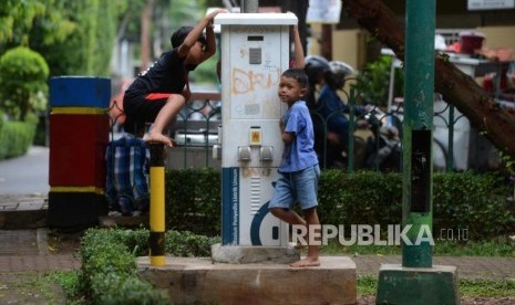 Anak bermain di taman tidak terawat. 