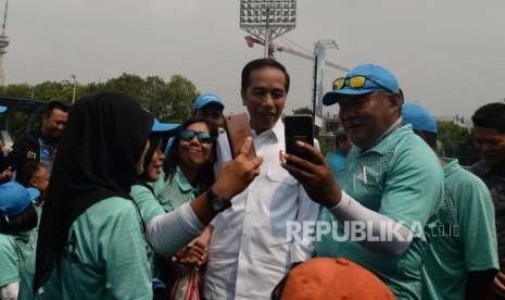 Presiden Republik Indonesia, Joko Widodo, (tengah) berswafoto bersama sejumlah atlet lawn ball saat melakukan peninjauan latihan lawn ball di kawasan Gelora Bung Karno, Jakarta, Kamis (27/9).