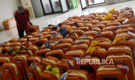 Bekal dan Barang yang Perlu Dibawa Jamaah Haji. Foto: Sejumlah porter merapihkan koper calon jamaah haji di Asrama Haji Pondok Gede, Jakarta, Ahad (14/7).