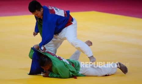 Atlet Kurash Indonesia Adesta Putu Wiradamungga Adesta (baju hijau) saat bertanding dengan Atlet Kurash China Taipei Yuhsuan Lo pada cabang olahraga kurash Asian Games 2018 kategori putra 90 kilogram di JCC, Jakarta, Kamis (30/8).