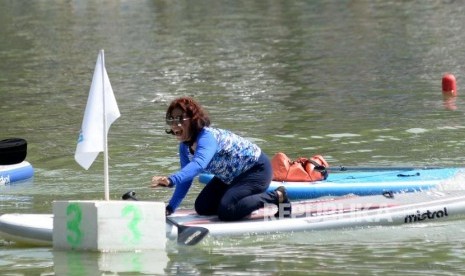 Menteri Kelautan dan Perikanan Susi Pudjiastuti berusaha mengambil bendera pada garis finish saat berlomba adu cepat dengan Wagub DKI Jakarta Sandiaga Uno dalam festival Danau Sunter, Jakarta, Ahad (25/2).