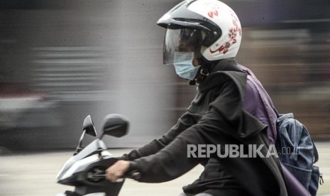 Pengendara motor menggunakan masker saat kabut asap kebakaran hutan dan lahan menyelimuti Kota Pekanbaru, Riau, Selasa (10/9).