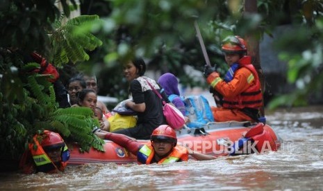 Petugas pemadam kebakaran mengevakuasi warga yang terjebak banjir di kawasan Pejaten Timur,Jakarta, Senin (5/2).