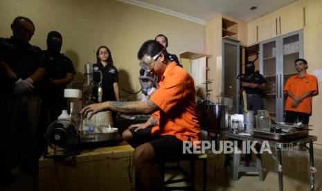 Tersangka mempraktekan pembuatan narkoba liquid vape saat pengungkapan kasus sindikat narkotika jenis liquid vape di Kelapa Gading, Jakarta Utara, Kamis (8/11).