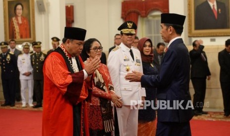 Pelantikan Hakim MK. Presiden Joko Widodo (kanan) bersiap memberikan ucapan selamat kepada Hakim Konstitusi Arief Hidayat (kiri) usai pelantikan Hakim Konstitusi di Istana Negara, Jakarta, Selasa (27/3).