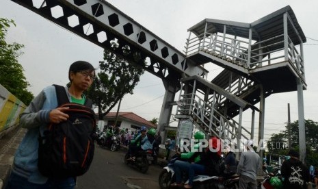 JPO Pasar Minggu. Warga dan kendaraan melintas di dekat Jembatan Penyeberangan Orang (JPO) yang rusak di Pasar Minggu, Jakarta, Selasa (5/3).