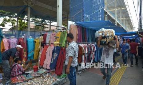 Warga melintas didekat barang dagangan para pedagang di Jalan Jatibaru, Tanah Abang, Jakarta, Kamis (27/9).