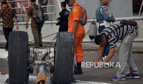 Petugas memfoto roda pesawat Lion Air JT 610 usai diturunkan dari kapal LCU KRI Banda Aceh saat tiba Posko Terpadu Pelabuhan Tanjung Priok, Jakarta, Sabtu (3/11).