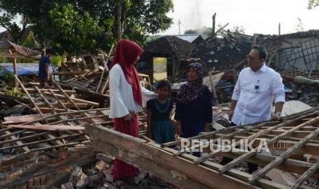 Corporate Secretary Bank Syariah Mandiri (BSM) Ahmad Reza (kanan) didampingi Kepala Cabang BSM Mataram Nur Intan (kiri) meninjau kondisi puing-puing bangunan yang terdampak gempa di Lombok Barat, Nusa Tenggara Barat, Senin (20/8).